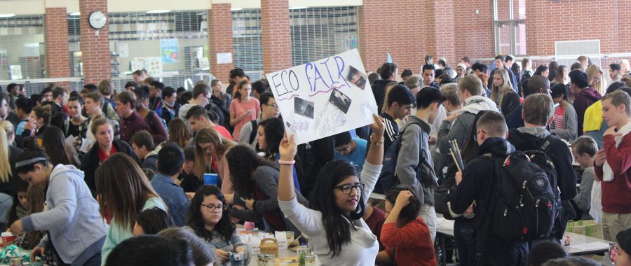 Students fill the cafeteria with signs that advertise their product. 