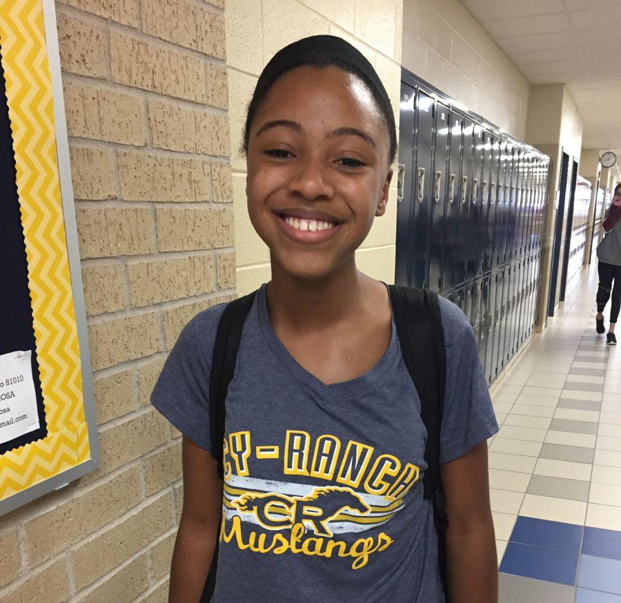 Jones poses outside of her classroom while wearing a Cypress Ranch Mustangs shirt.