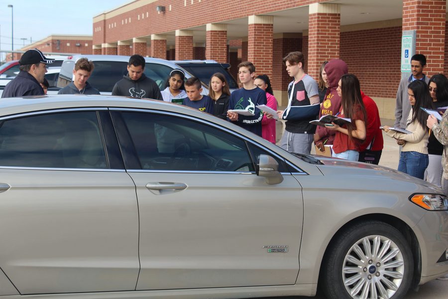 Spanish students inspect the Ford electronic vehicle. 