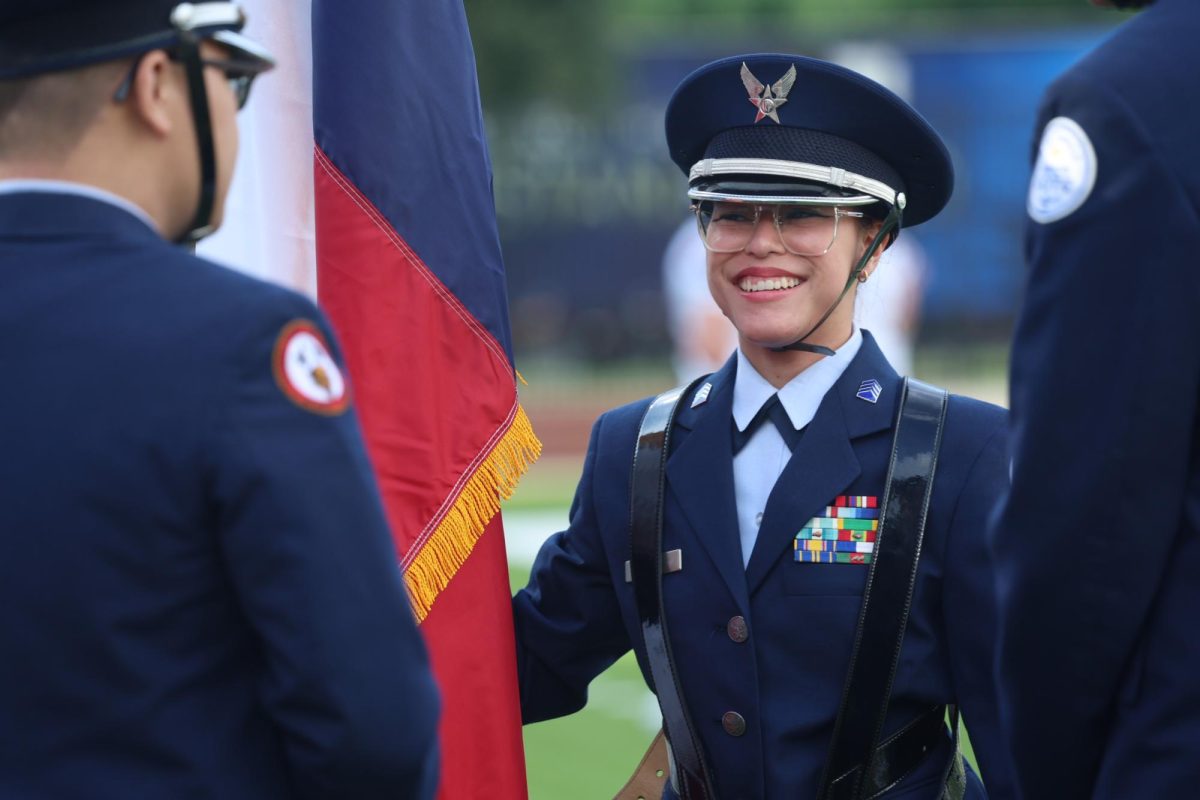 An ROTC student smiles on the field during the varsity football game vs. Tompkins High School.